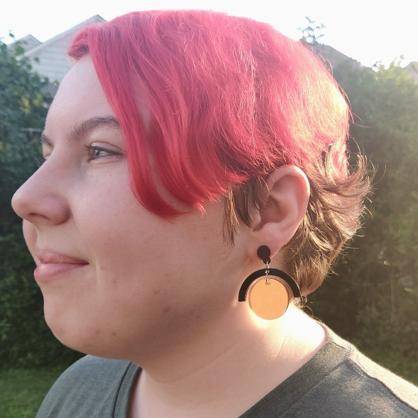 Geometric black and gold circle earrings on model