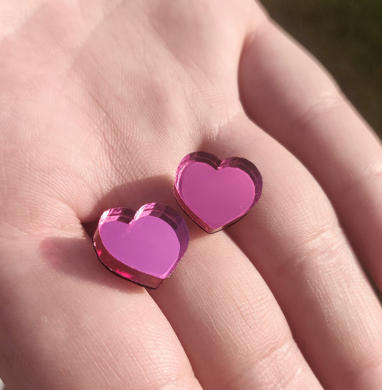 Pink heart studs in hand