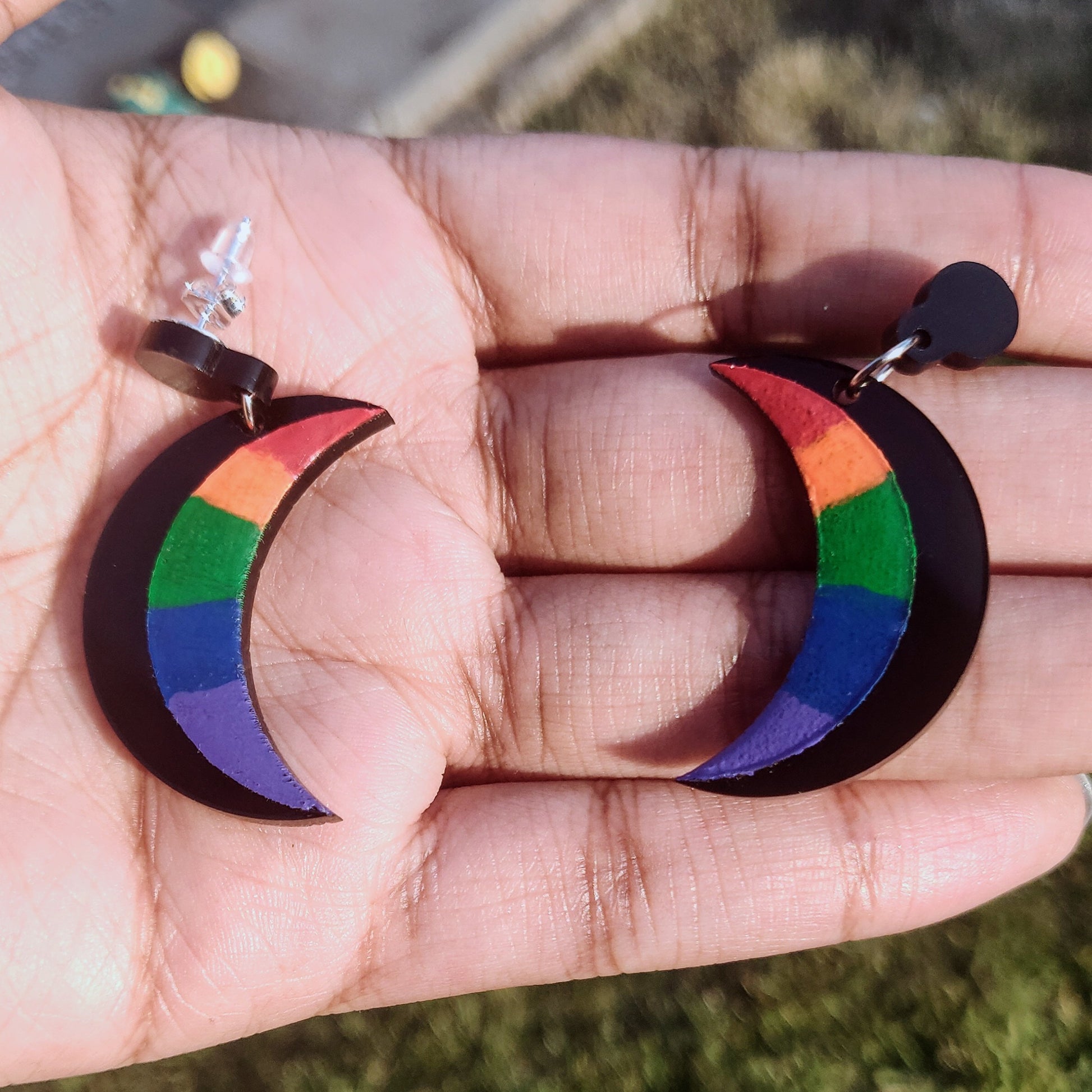 Rainbow and black crescent Moon earrings in hand