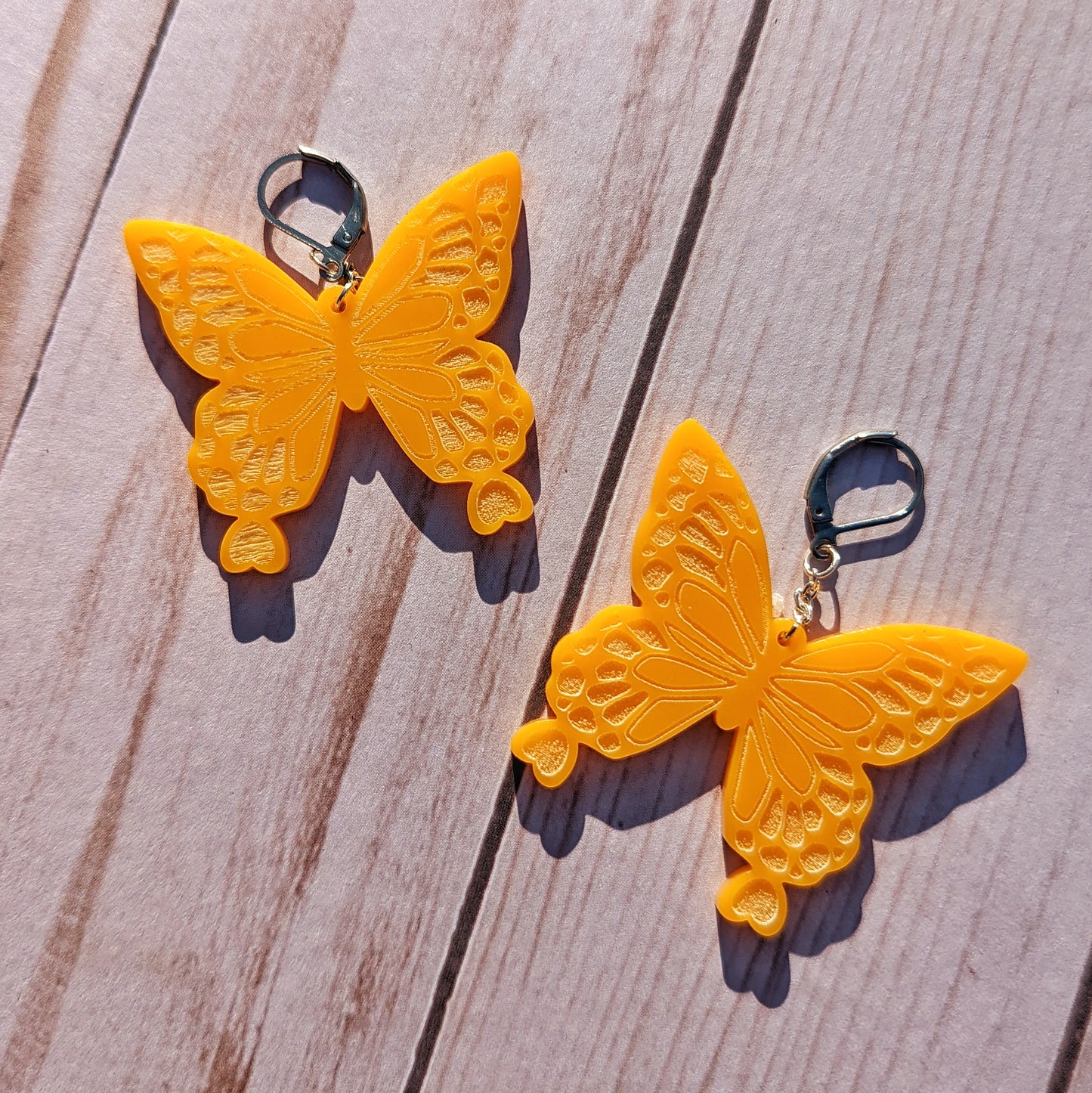 Pastel orange butterfly earrings. Engraved including hearts at the bottoms of the wings.